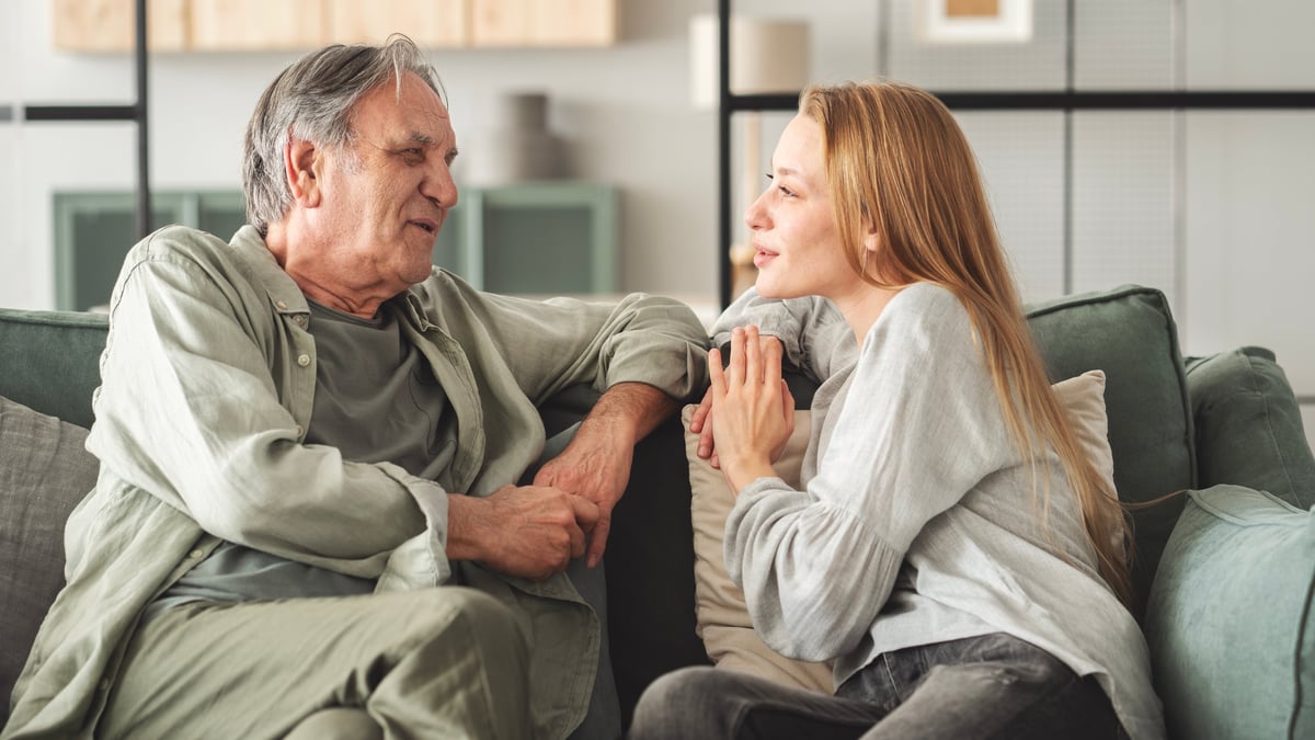 Padre e hija conversando tranquilamente, sentados uno frente al otro